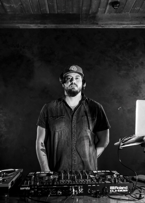 Bear Cole wearing headphones behind his DJ decks